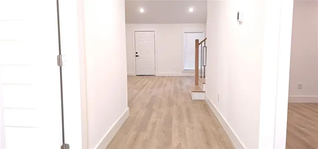 a view of a hallway with wooden floor