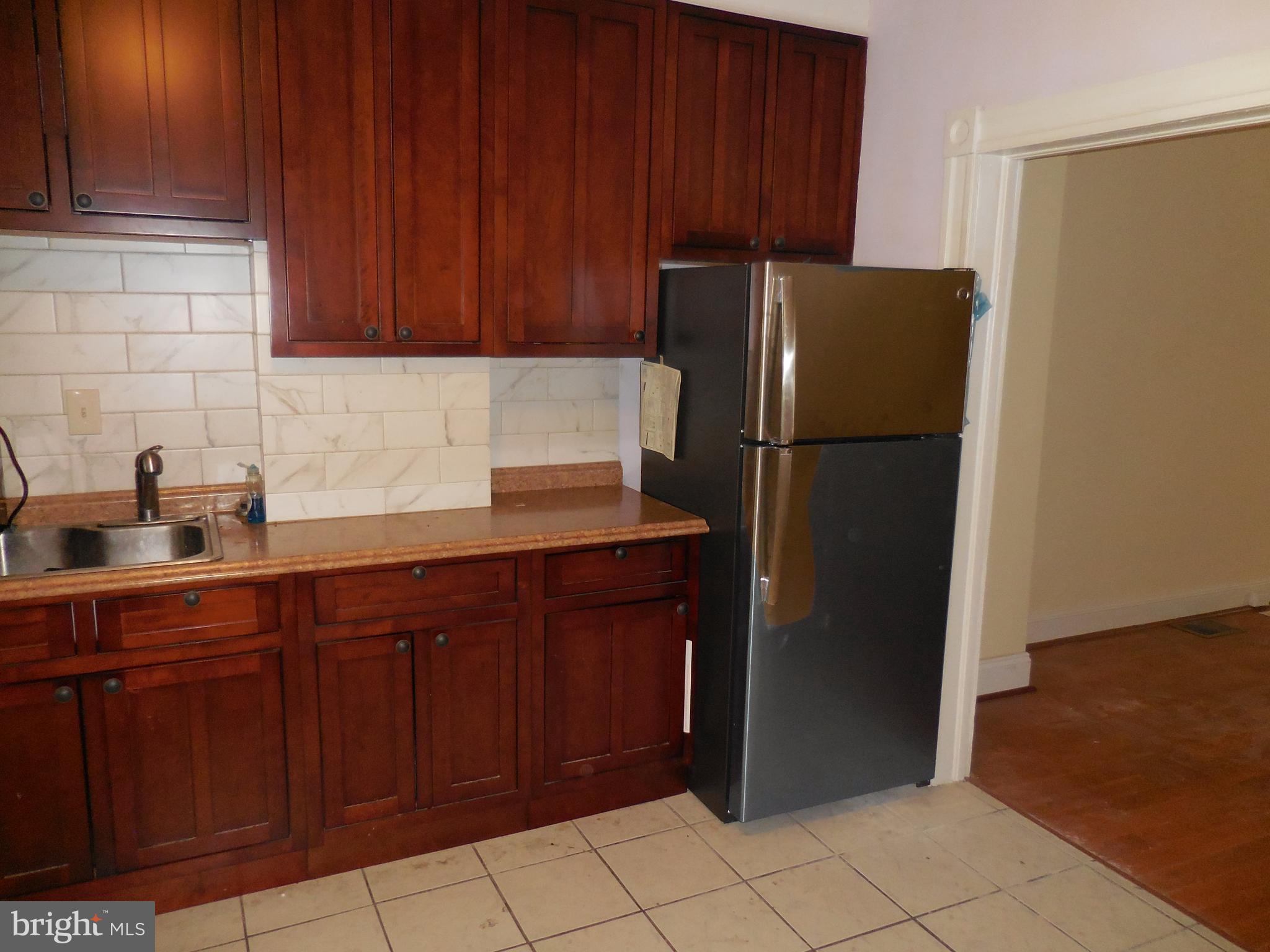 603 East 36th Street Baltimore, MD 21218 - Photo 8 of 29 a kitchen with stainless steel appliances granite countertop a refrigerator and a sink