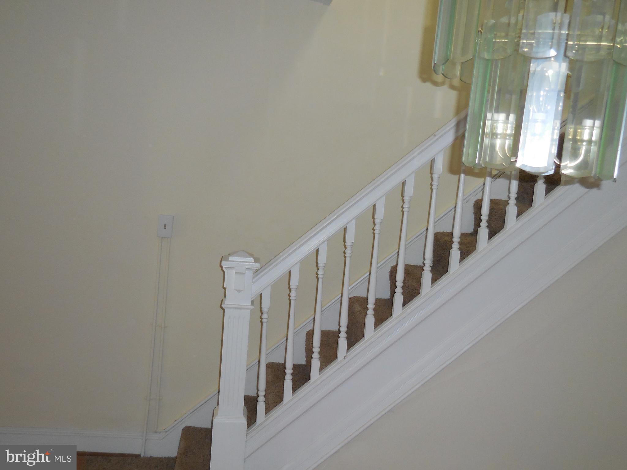 603 East 36th Street Baltimore, MD 21218 - Photo 10 of 29 a view of staircase with lots of frames on wall and a window