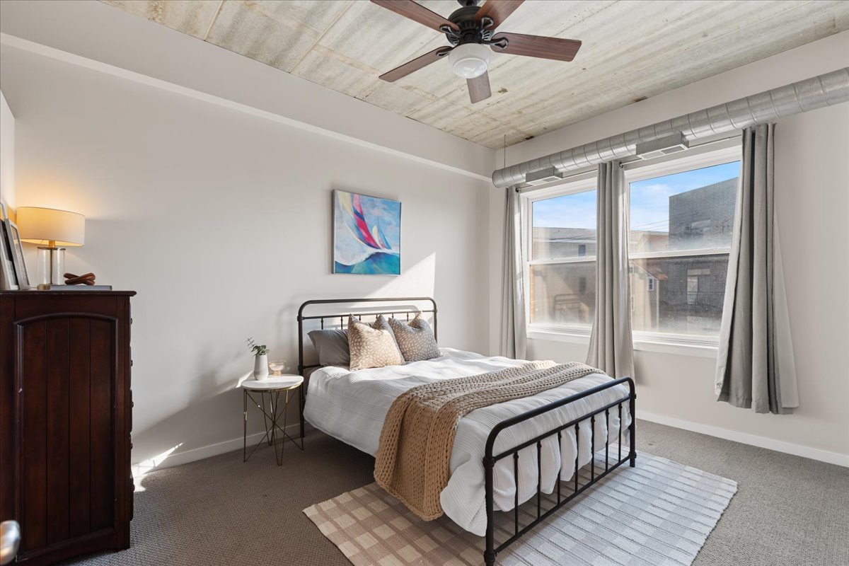 3260 North Clark Street, Unit 306 Chicago, IL 60657 - Photo 11 of 17 a bedroom with a bed wooden floor and window