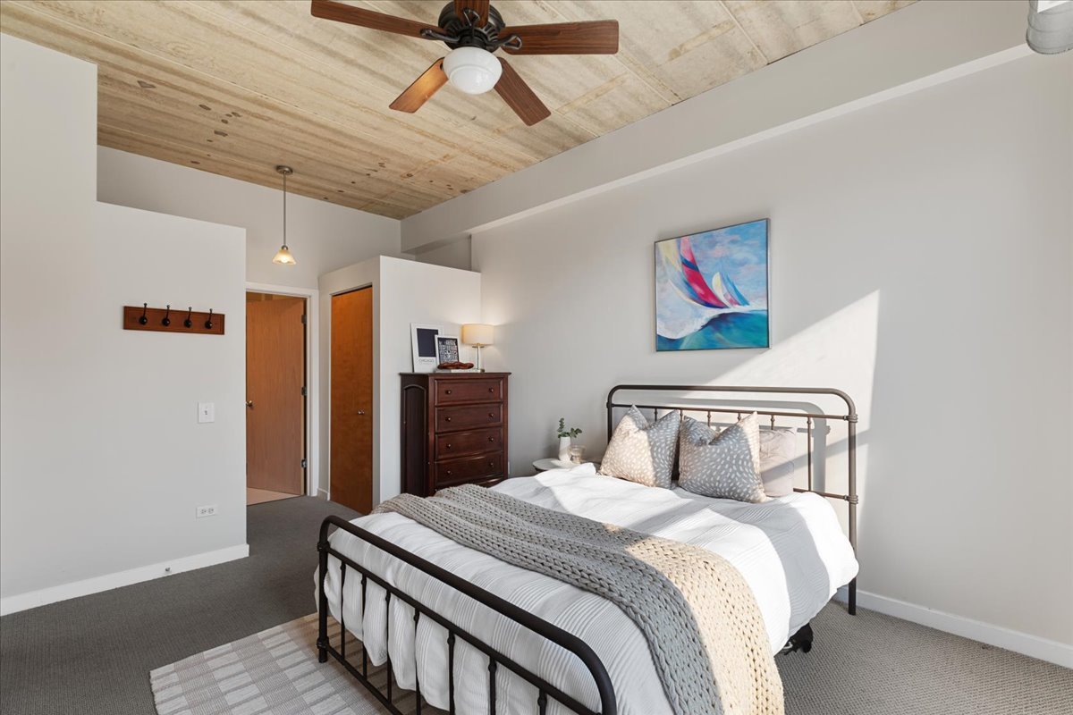 3260 North Clark Street, Unit 306 Chicago, IL 60657 - Photo 12 of 17 a bedroom with a bed and a chandelier