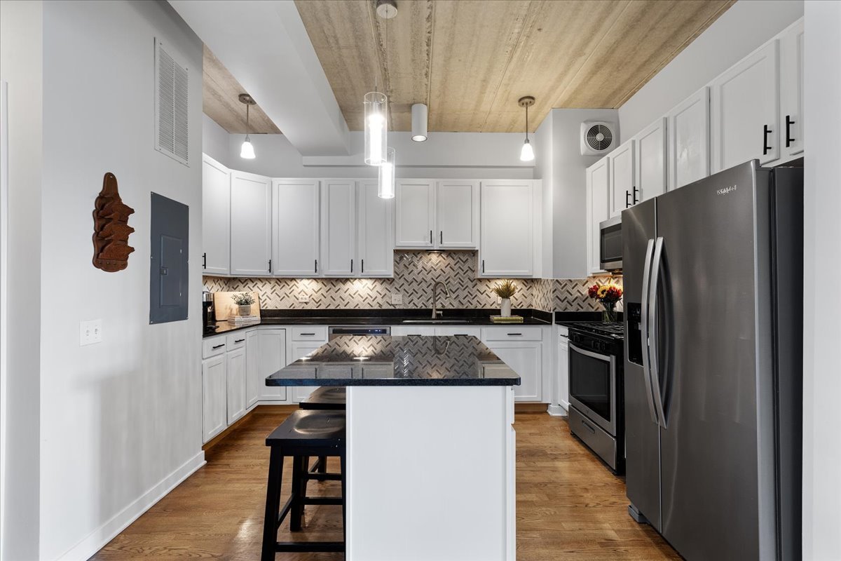 3260 North Clark Street, Unit 306 Chicago, IL 60657 - Photo 4 of 17 a kitchen with granite countertop a refrigerator and a stove top oven