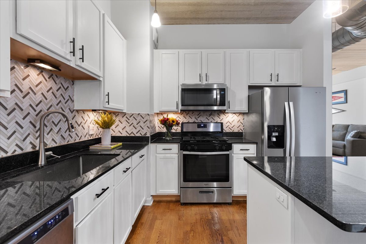 3260 North Clark Street, Unit 306 Chicago, IL 60657 - Photo 5 of 17 a kitchen with granite countertop a sink stove and refrigerator