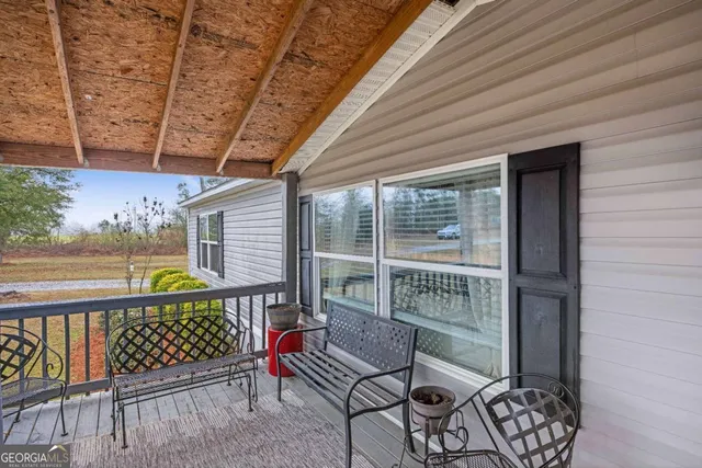 a balcony with chairs and wooden fence
