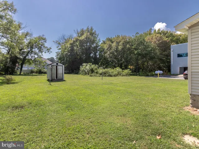 a view of a house with a big yard and large trees