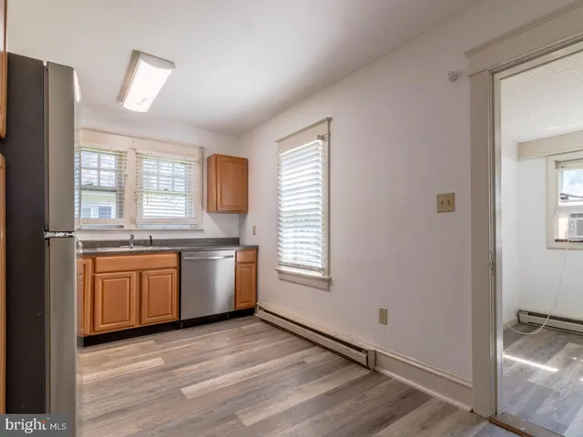a view of a kitchen with a sink dishwasher and wooden floor