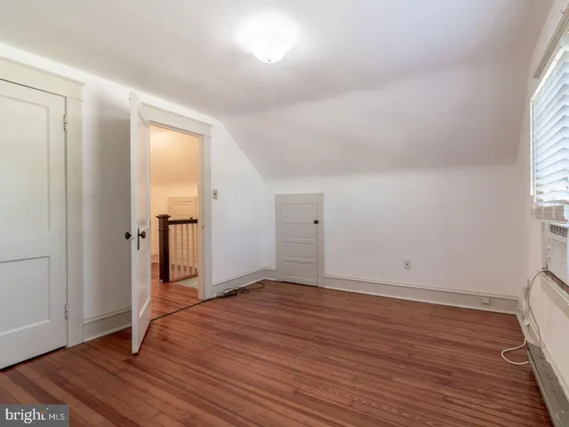 an empty room with wooden floor & windows
