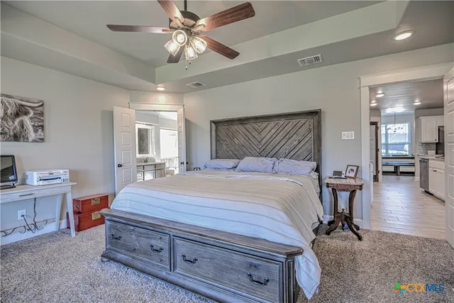 a bedroom with a large bed and a chandelier
