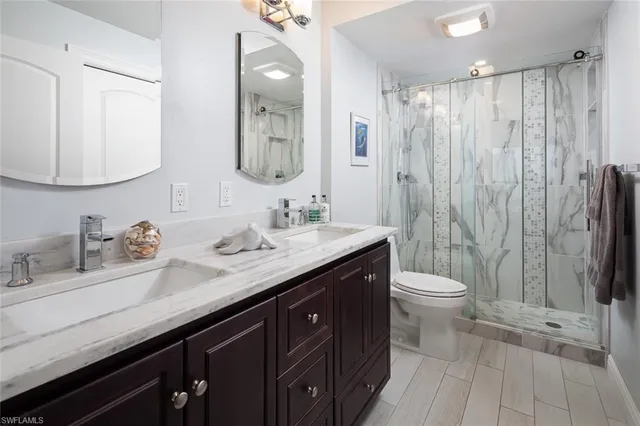 a bathroom with a double vanity sink toilet and a mirror