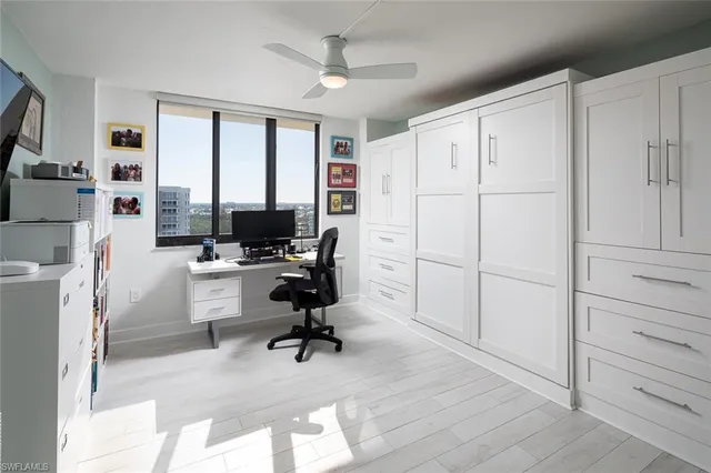 a view of a workspace with furniture and a window