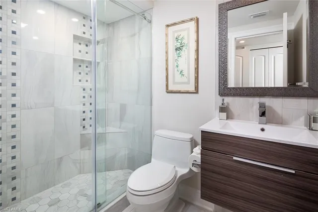 a bathroom with a toilet a sink and glass door