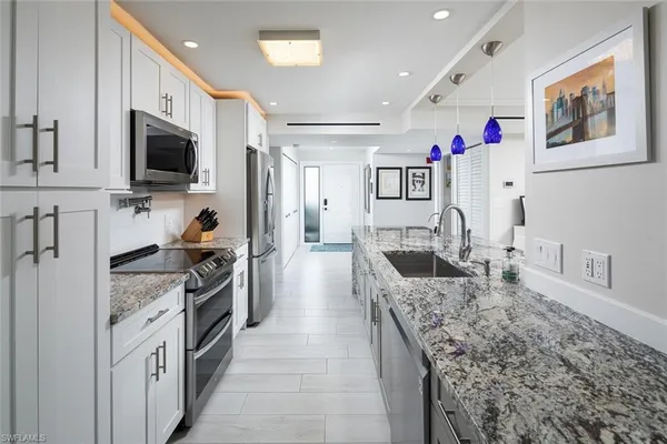 a large kitchen with stainless steel appliances granite countertop a lot of counter space and wooden floor