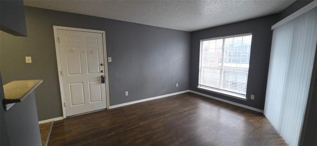 18333 Roehampton Drive, Unit 928 Dallas, TX 75252 - Photo 12 of 20 an empty room with wooden floor and windows
