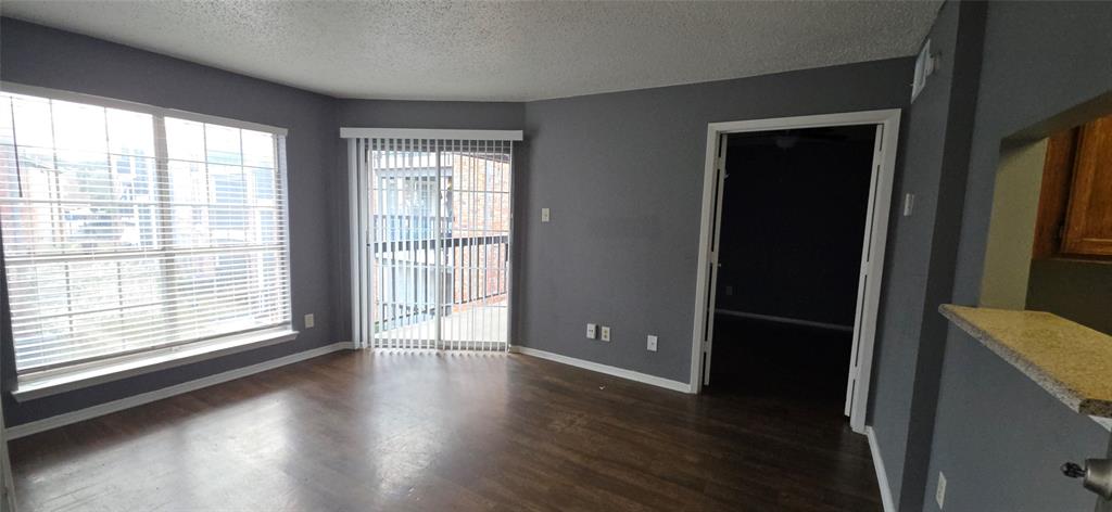 18333 Roehampton Drive, Unit 928 Dallas, TX 75252 - Photo 2 of 20 a view of an empty room with wooden floor and a window