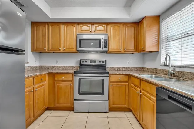 a kitchen with stainless steel appliances granite countertop a stove sink and cabinets