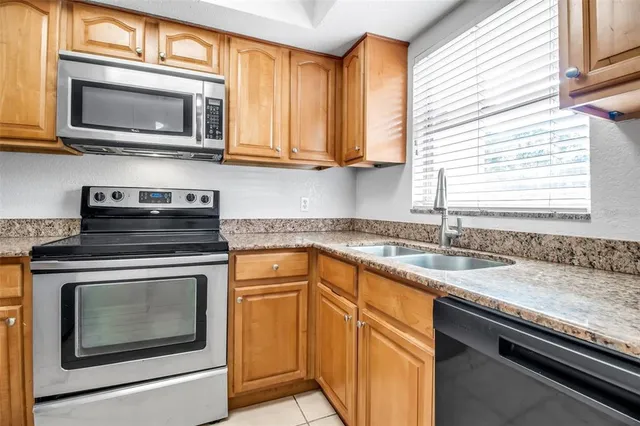 a kitchen with granite countertop cabinets stainless steel appliances and a sink