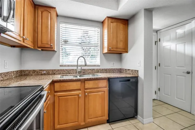 a kitchen with stainless steel appliances granite countertop a sink and a stove