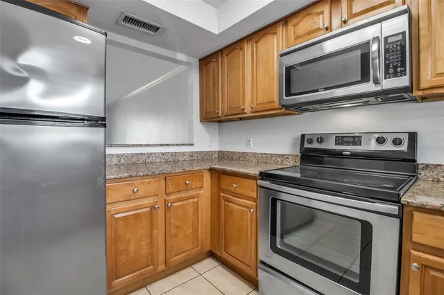 a kitchen with granite countertop cabinets stainless steel appliances and wooden cabinets