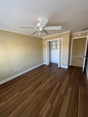 a view of a room with wooden floor and fan