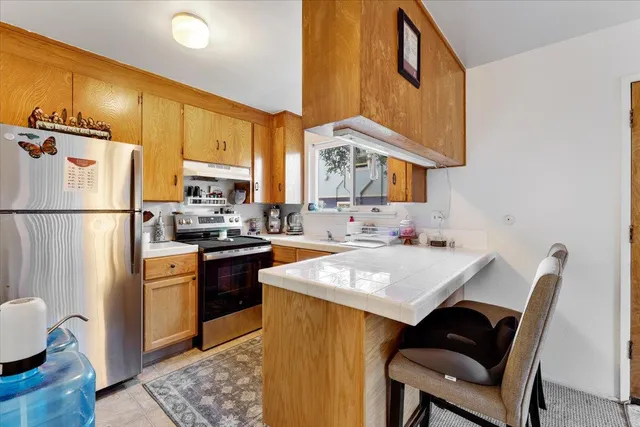 a kitchen with a sink a stove a refrigerator and cabinets