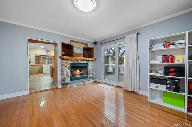 a view of a livingroom with wooden floor and a fireplace