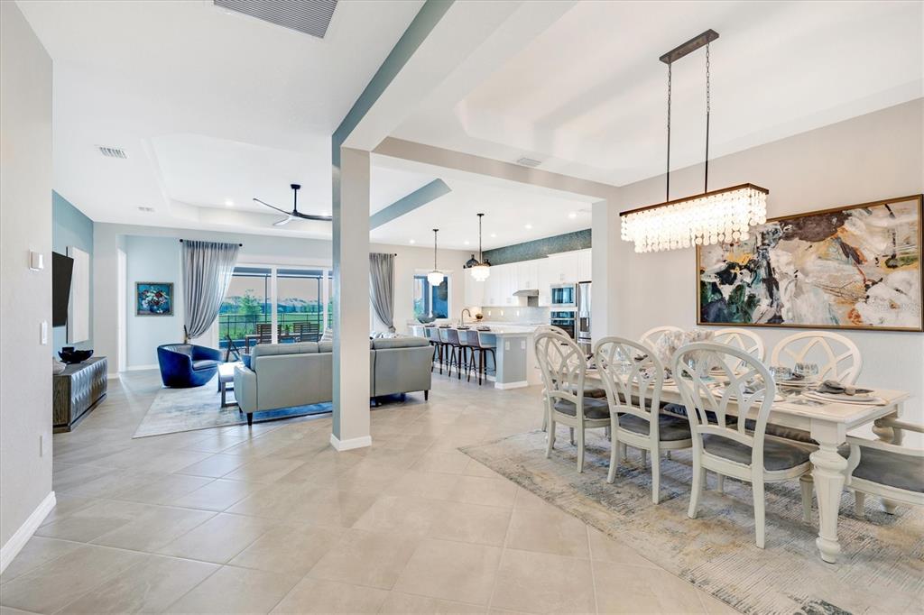 12736 Tulum Loop Venice, FL 34293 - Photo 19 of 93 a view of a dining room and livingroom with furniture wooden floor a chandelier