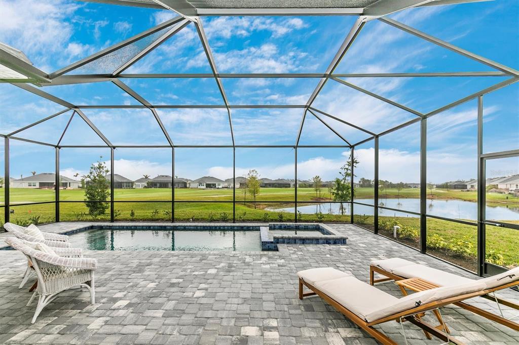 12736 Tulum Loop Venice, FL 34293 - Photo 24 of 93 a view of a terrace with a table and chairs under an umbrella