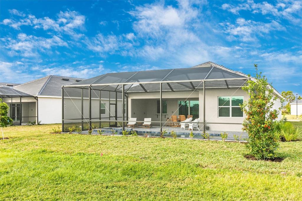 12736 Tulum Loop Venice, FL 34293 - Photo 45 of 93 a backyard of a house with table and chairs
