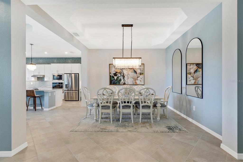 12736 Tulum Loop Venice, FL 34293 - Photo 5 of 93 a dining room with furniture a chandelier and window