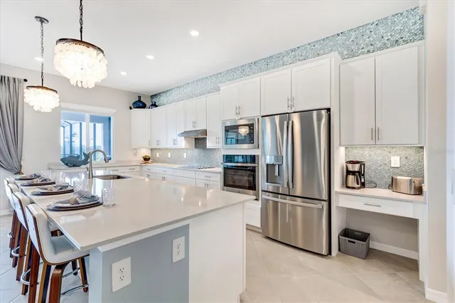 a living room with furniture kitchen view and a large window