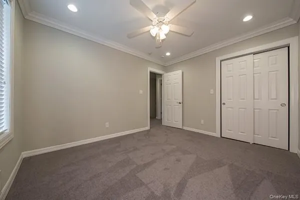 an empty room with a ceiling fan and a window