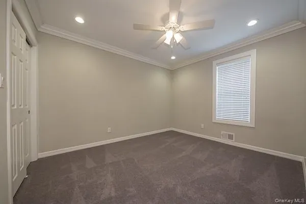 an empty room with a ceiling fan and a window