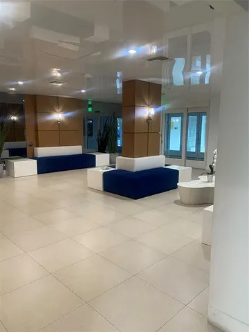 a lobby with furniture and a chandelier