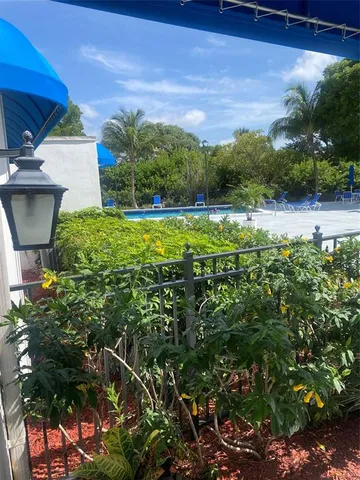 a view of a house with a yard and potted plants