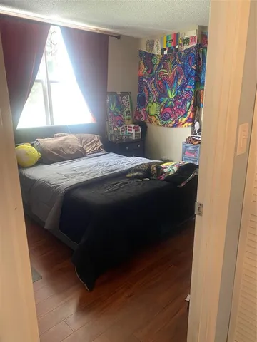 a bedroom with a bed and painting on the wall