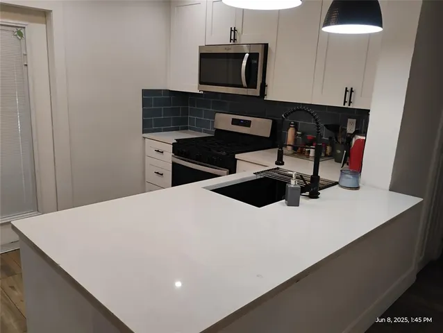 a kitchen with a sink a microwave and cabinets