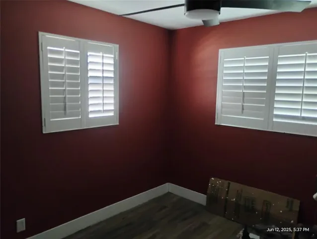 a backyard of a house with potted plants and large trees