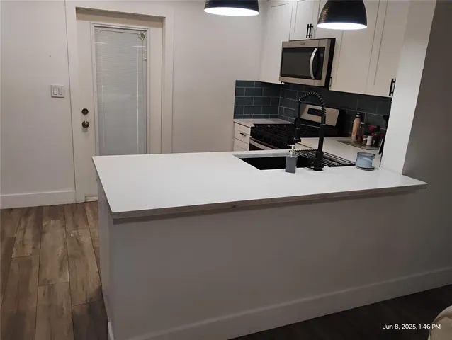 a room with a table chairs and appliances