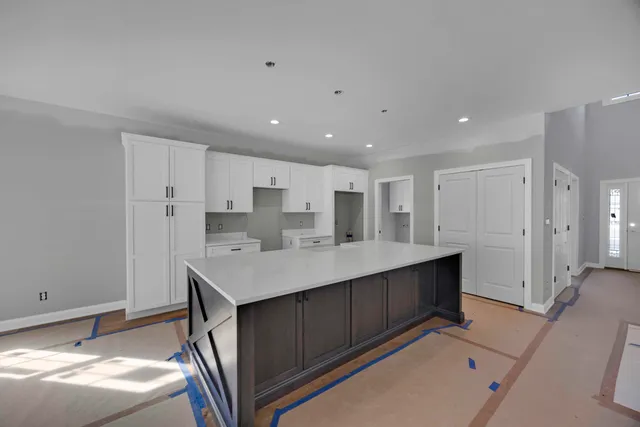a kitchen with kitchen island a sink appliances and cabinets
