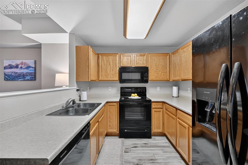 2141 Legacy Ridge View, Unit 109 Colorado Springs, CO 80910 - Photo 14 of 21 a kitchen with stainless steel appliances granite countertop a sink stove and refrigerator
