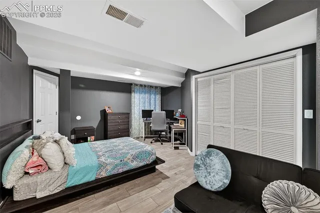 a bedroom with a bed and wooden floor