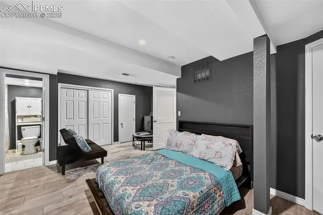 a bedroom with a bed and wooden floor