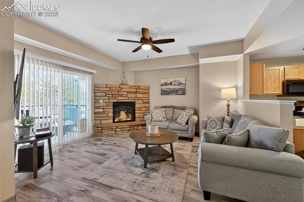 2141 Legacy Ridge View, Unit 109 Colorado Springs, CO 80910 - Photo 3 of 21 a living room with furniture a fireplace and a large window
