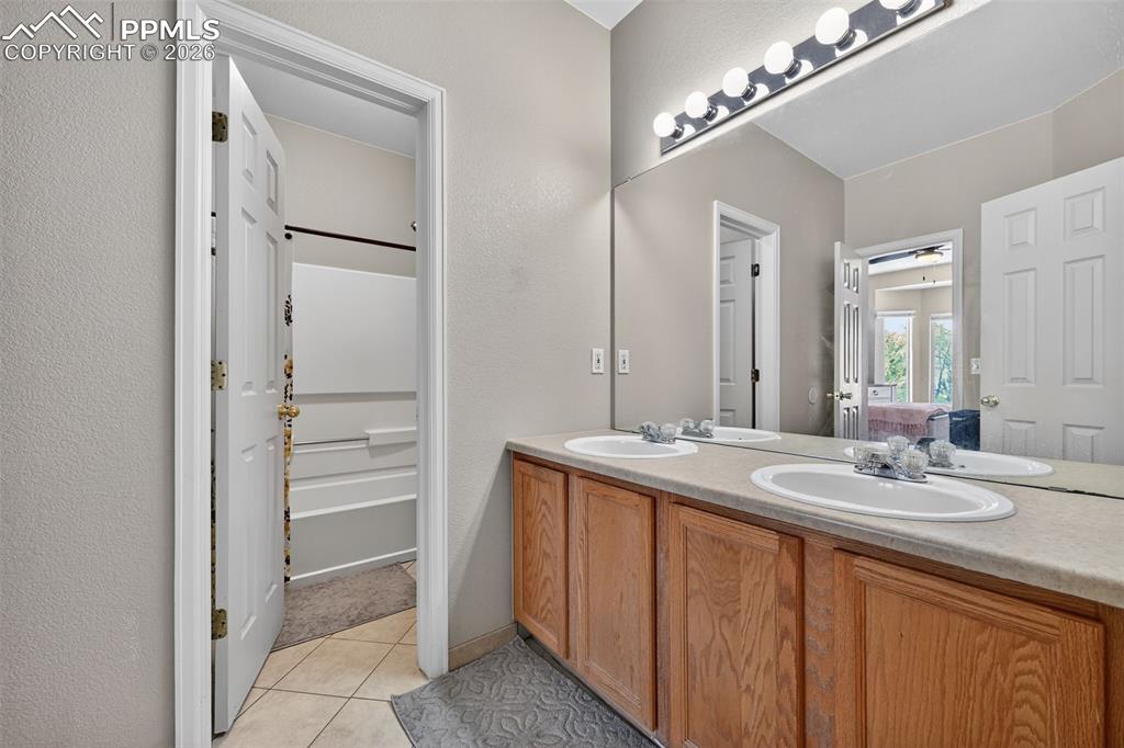 2141 Legacy Ridge View, Unit 109 Colorado Springs, CO 80910 - Photo 7 of 21 a bathroom with a double vanity sink and mirror