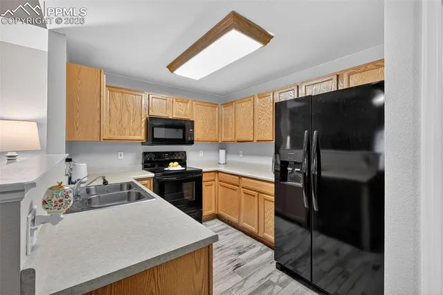 a kitchen with granite countertop a refrigerator stove top oven a sink and dishwasher