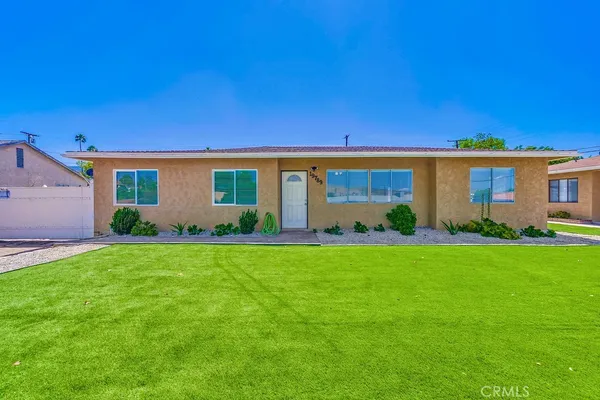 a front view of house with a garden