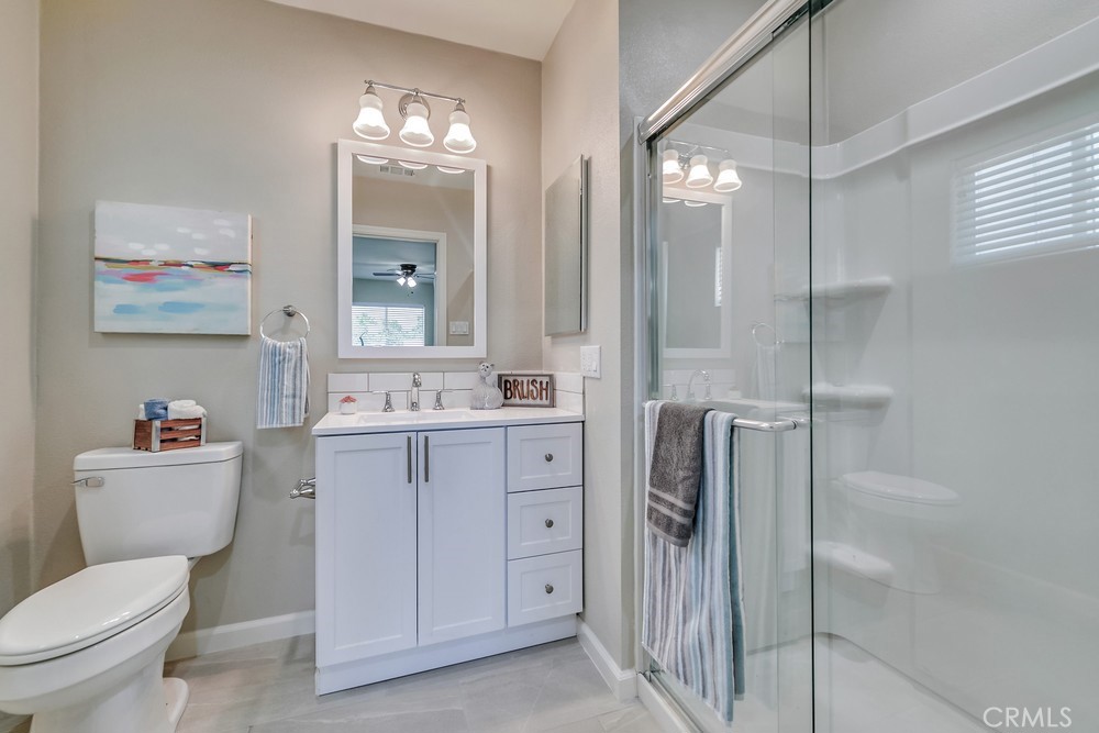 19789 Evelyn Street Corona, CA 92881 - Photo 11 of 22 a bathroom with a toilet a sink a mirror a vanity and shower