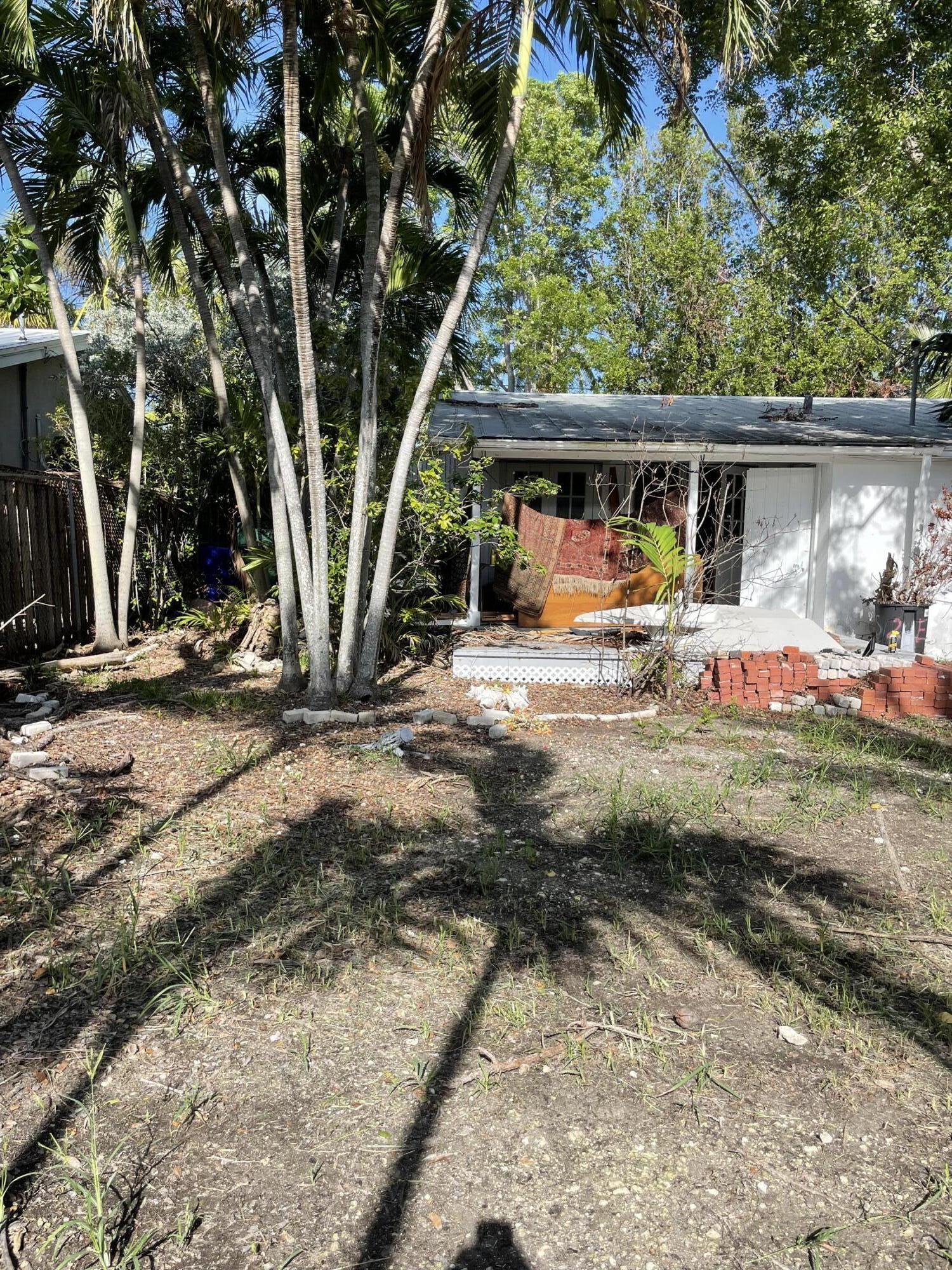 1716 Laird Street Key West, FL 33040 - Photo 4 of 32 a view of backyard with a table and chairs under an umbrella