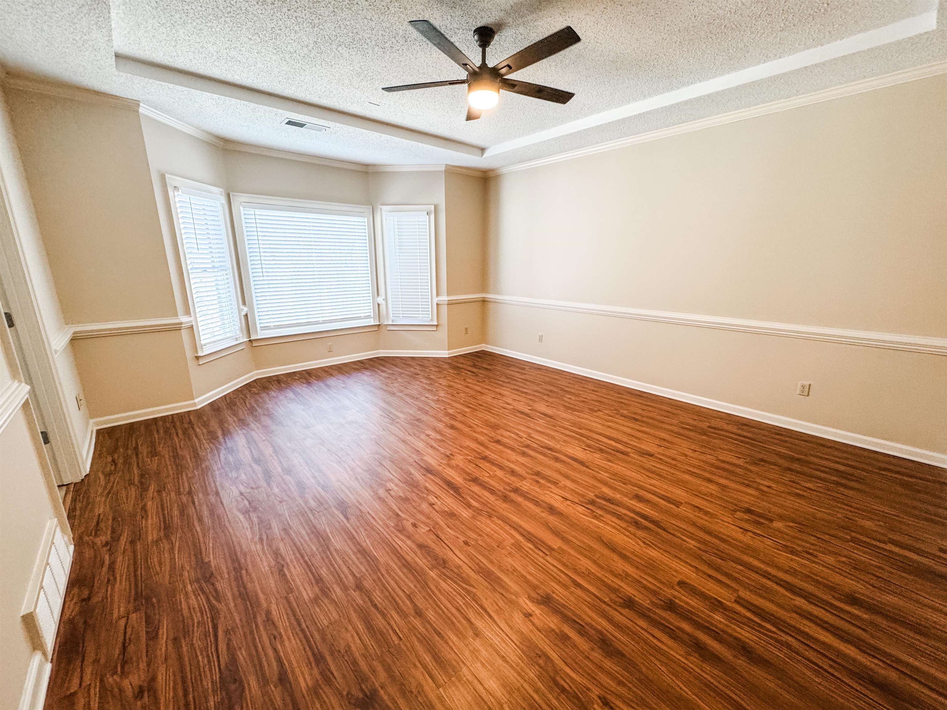 158 Eulas Ridge Cove Collierville, TN 38017 - Photo 11 of 18 Spare room featuring crown molding, dark wood-style floors, visible vents, and a textured ceiling