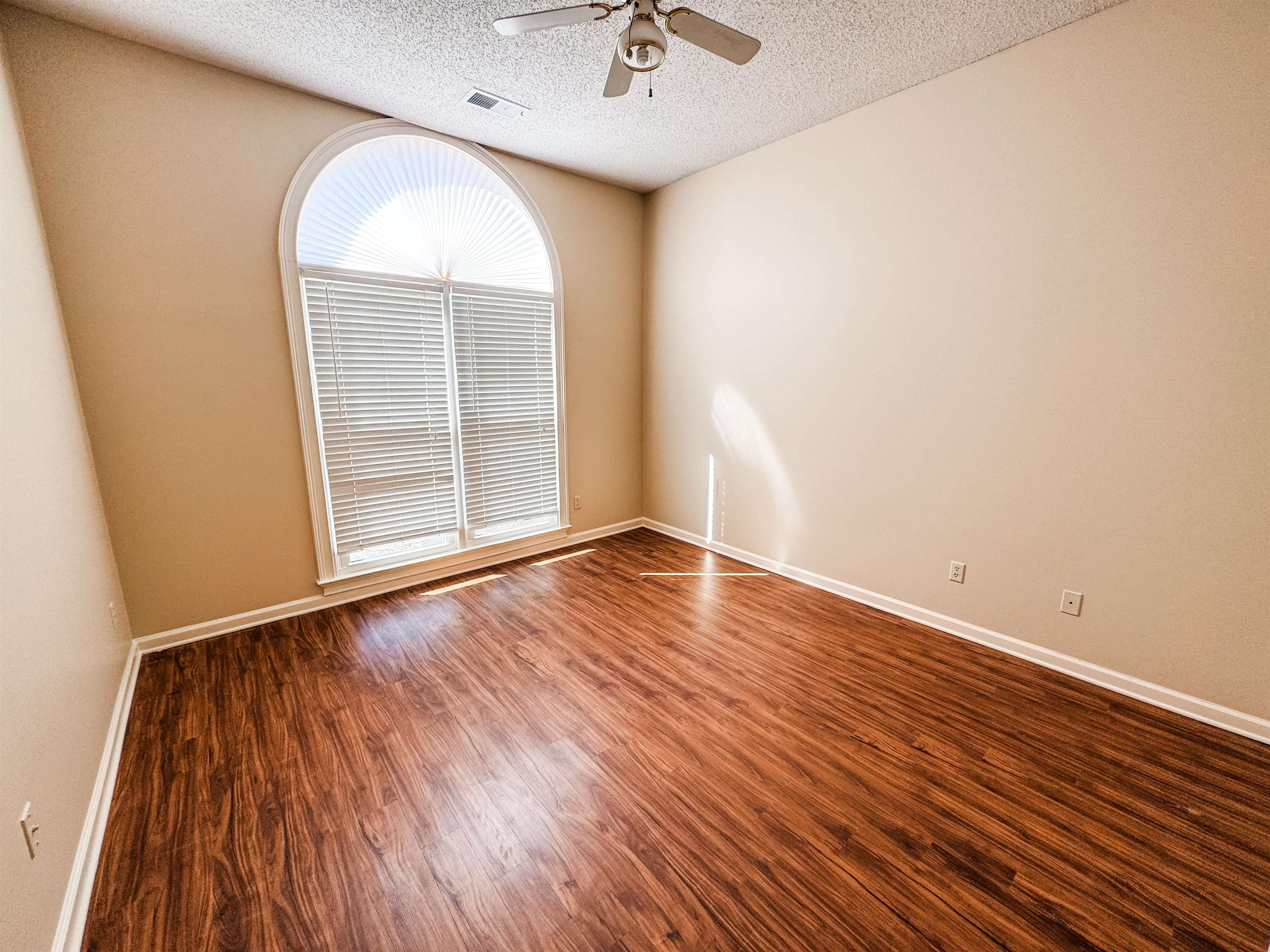 158 Eulas Ridge Cove Collierville, TN 38017 - Photo 13 of 18 Empty room with visible vents, a textured ceiling, wood finished floors, baseboards, and ceiling fan